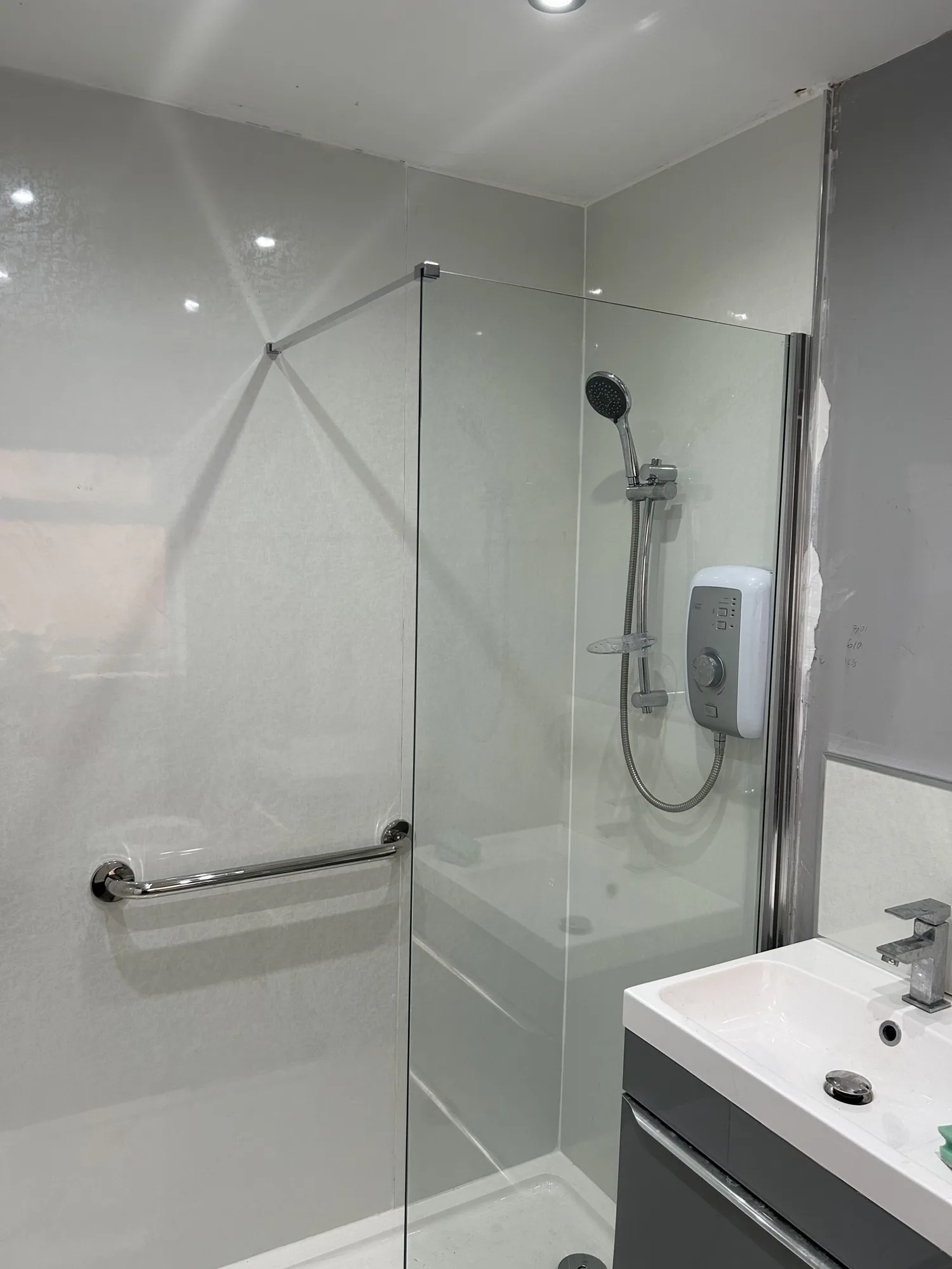 Shower room with sparkle wall panels, glass screen and electric shower