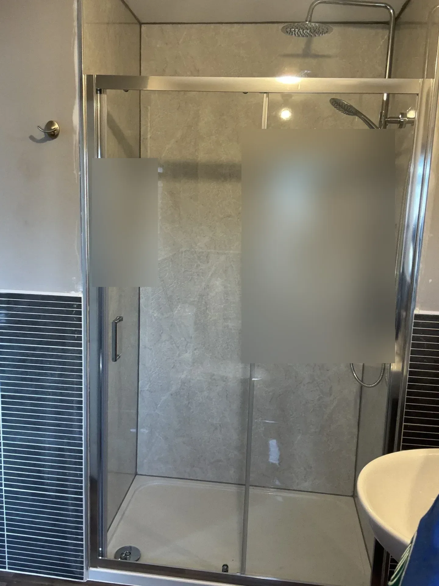 Sliding-door shower enclosure with grey marble-effect wall panels